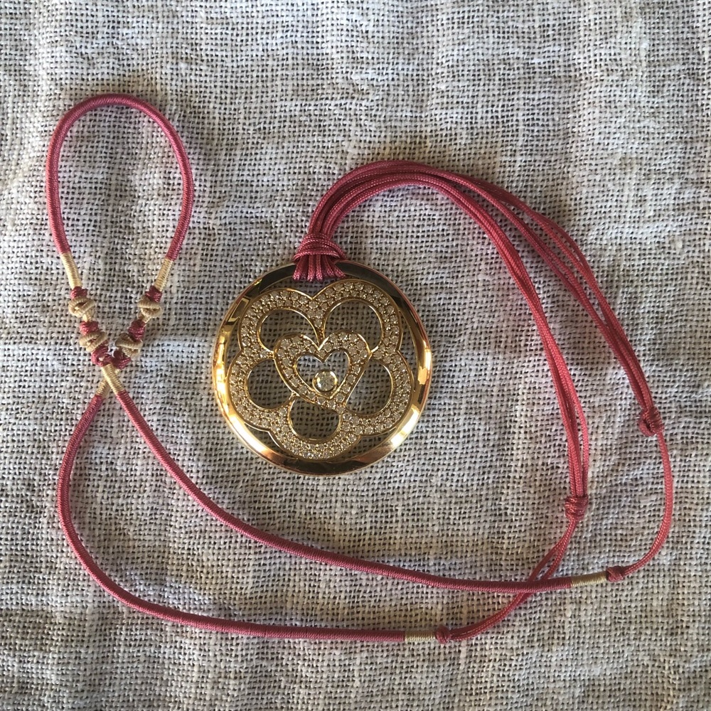 Escada 18 karat yellow gold diamond pendant on silk cord.
